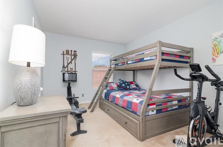 A bunk bed in a room with a white lamp and a grey dresser.