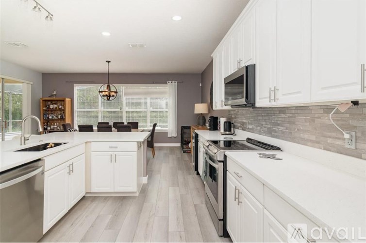 A modern kitchen with white cabinets and stainless steel appliances.