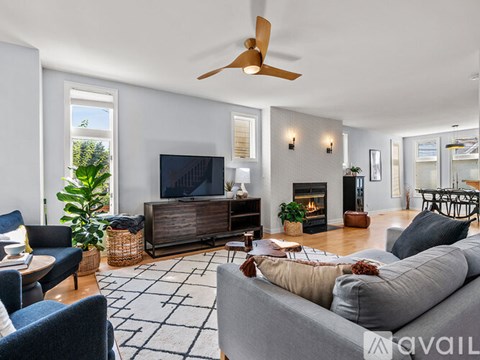 A living room with a grey sofa and a wooden entertainment center.