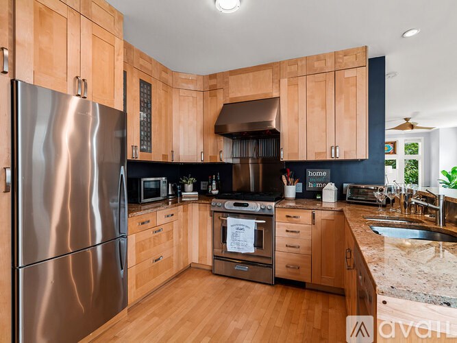 A kitchen with wooden cabinets and a stainless steel refrigerator.