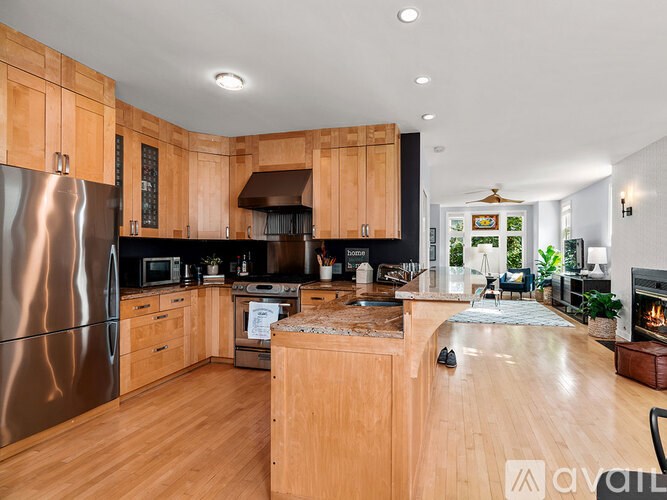 A modern kitchen with wooden cabinets and a stainless steel refrigerator.
