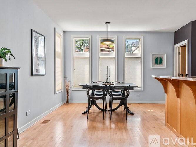 A dining room with a wooden table and chairs.
