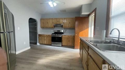 A kitchen with wooden cabinets and a stainless steel refrigerator.