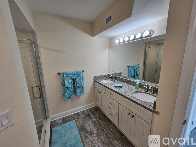 A bathroom with a sink, mirror, and a blue towel.