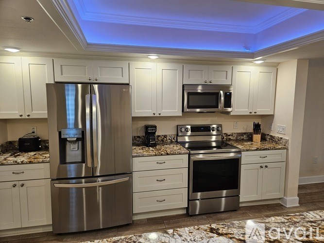 A modern kitchen with stainless steel appliances and white cabinets.