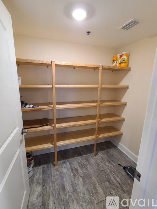 A room with a white door and a shelving unit with 12 shelves.