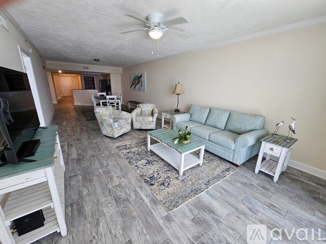 A living room with a television, couch, and rug.