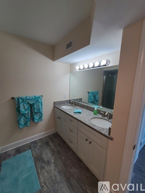 A bathroom with a vanity, mirror, and lights.