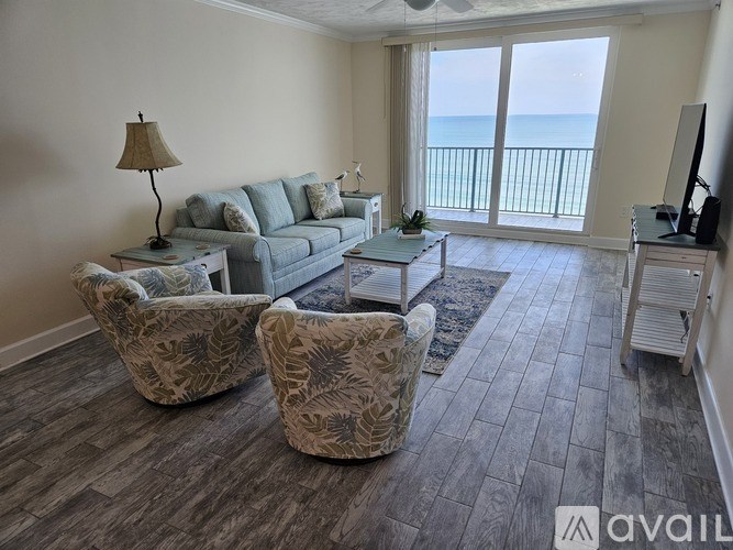 A living room with a grey couch, two chairs and a coffee table.