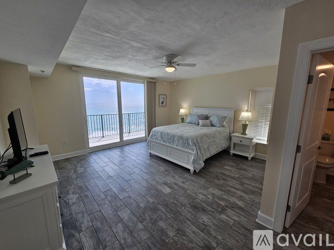A bedroom with a large bed and sliding glass doors.