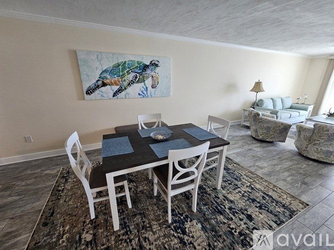 A dining room with a table set for two and a painting of a turtle on the wall.