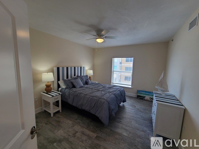 A bedroom with a bed, nightstand, and window.