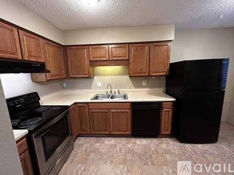 A kitchen with wooden cabinets and black appliances.