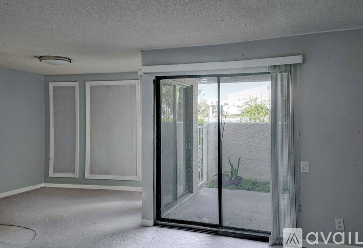 A room with a sliding glass door leading to a backyard.
