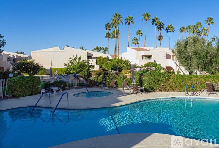 A pool with a slide and a house in the background.