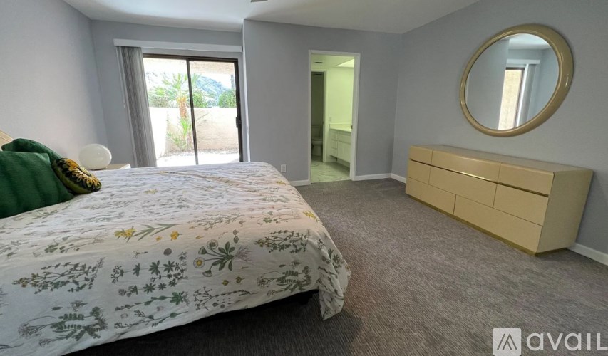 A bedroom with a bed, dresser, and mirror.