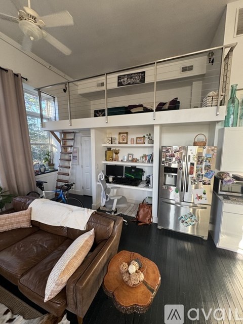 A living room with a brown leather couch and a wooden coffee table.