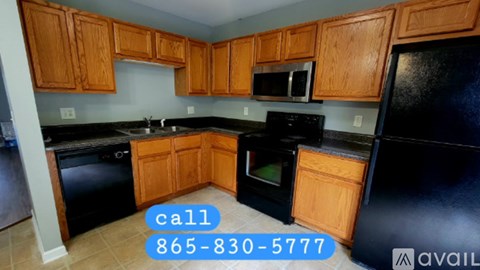 A kitchen with black appliances and wooden cabinets.
