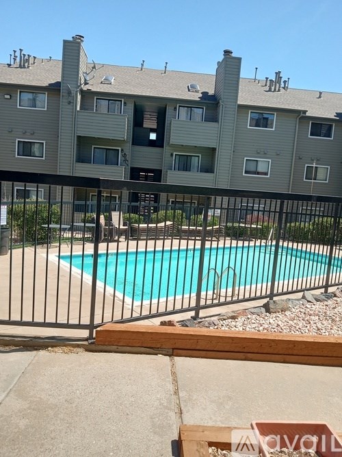 Apartment complex with a pool in front.