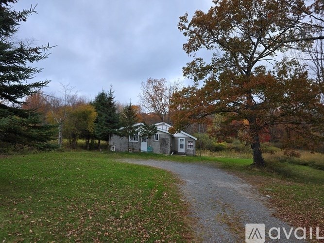 A house is situated in a grassy area with a path leading to it.