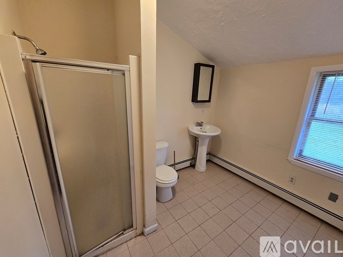 A bathroom with a toilet, sink, and shower.