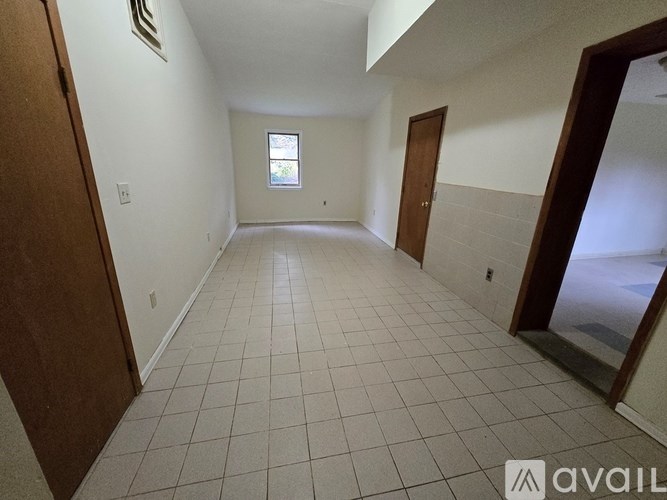 A room with tiled flooring and a window.