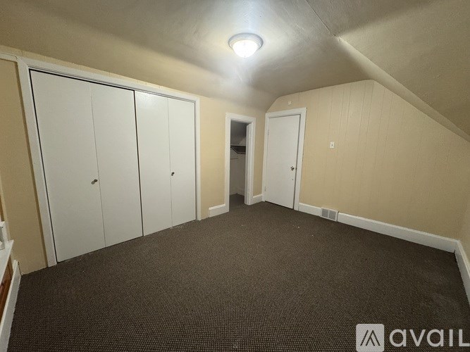 A room with a carpeted floor and a white door.