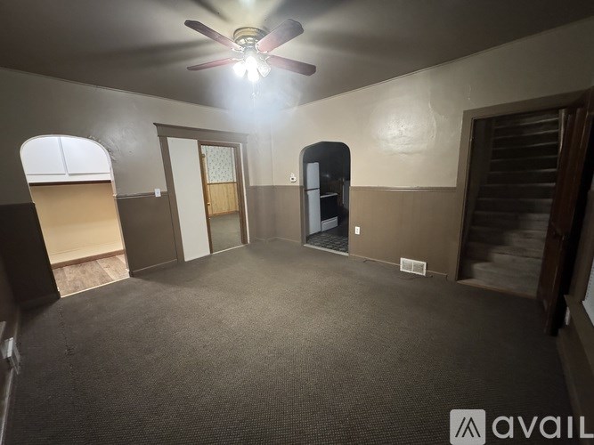 A room with a ceiling fan and a carpeted floor.