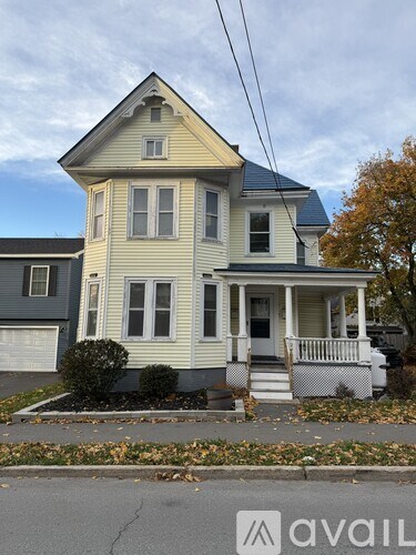 A two-story house with a front porch and a small front yard.