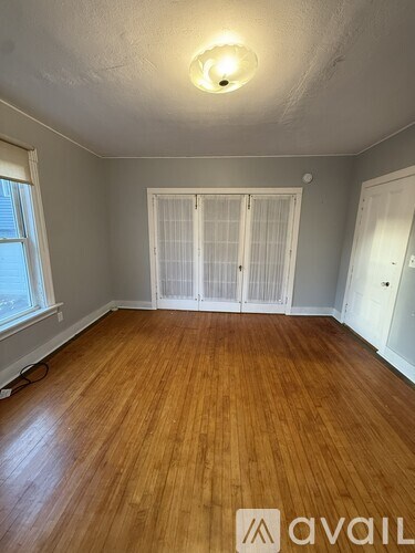 A room with wooden flooring and white doors.