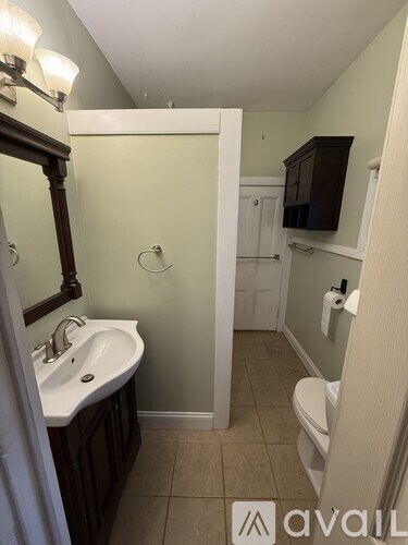 A bathroom with a sink, toilet, and a mirror.