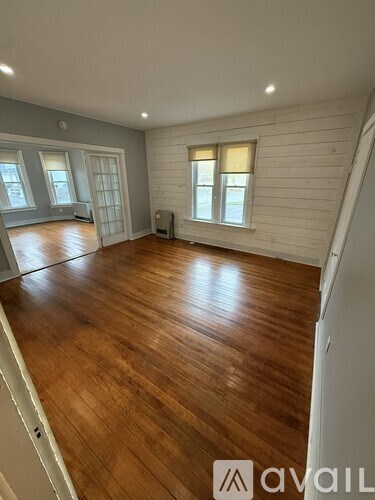 A room with wooden flooring and white walls.