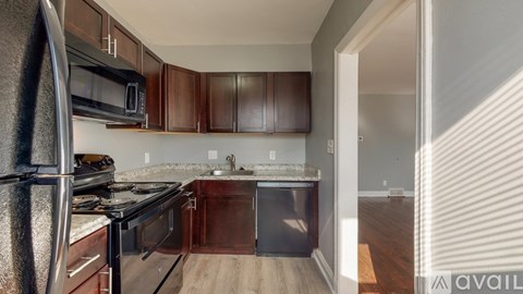A kitchen with dark wood cabinets and stainless steel appliances.