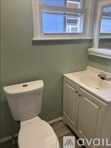 A white toilet and sink in a bathroom.