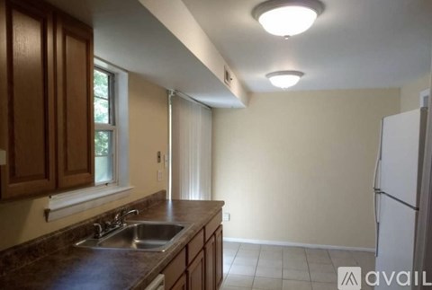 A kitchen with brown cabinets and a white refrigerator.