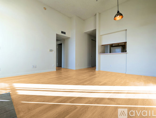 A room with wooden floors and a hanging light fixture.
