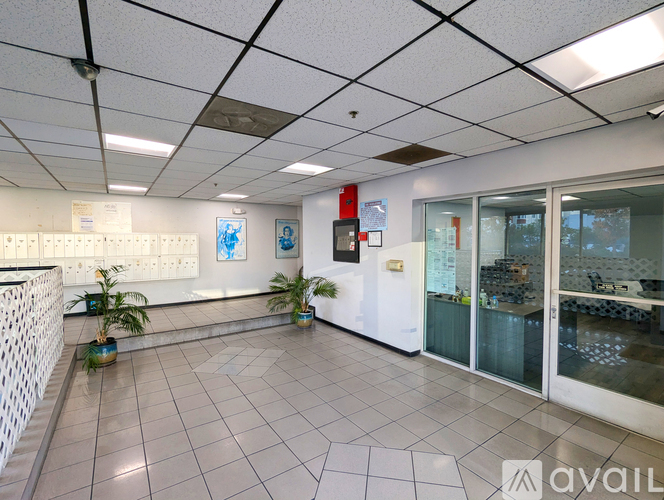 A white tiled office space with a glass door leading to a balcony.