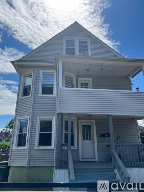 A two-story house with a white door and windows.