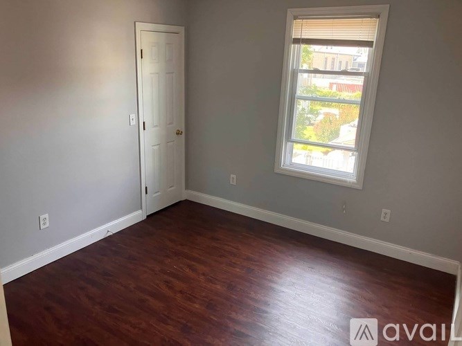 A room with a white door and a window with blinds.