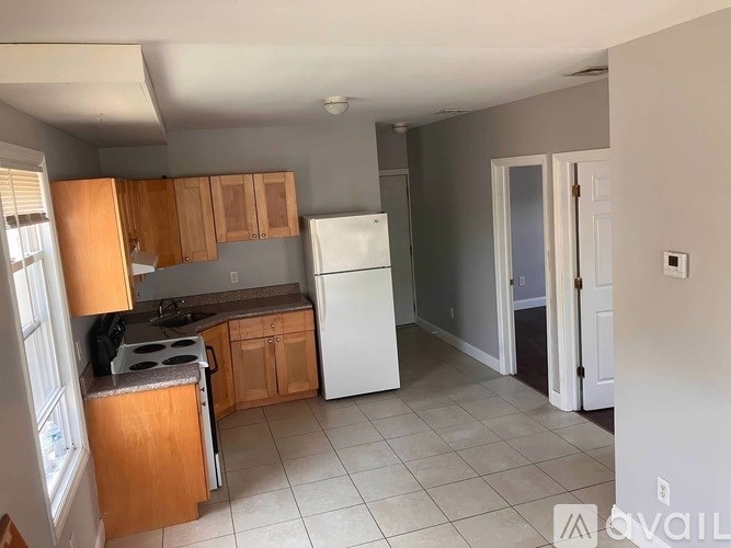 A kitchen with wooden cabinets and a white refrigerator.