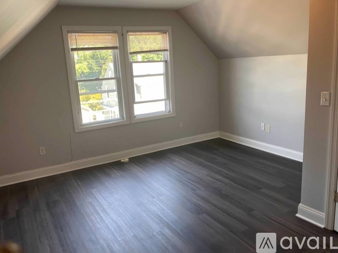 A room with a window and wooden flooring.