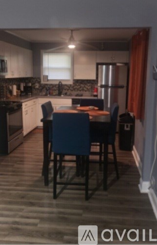 A kitchen with a table and chairs in the middle.