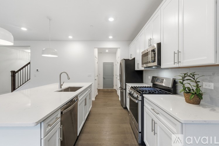 A modern kitchen with white cabinets and stainless steel appliances.