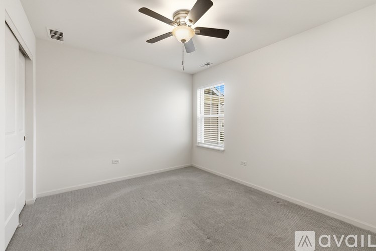 A room with a ceiling fan and carpeted floor.