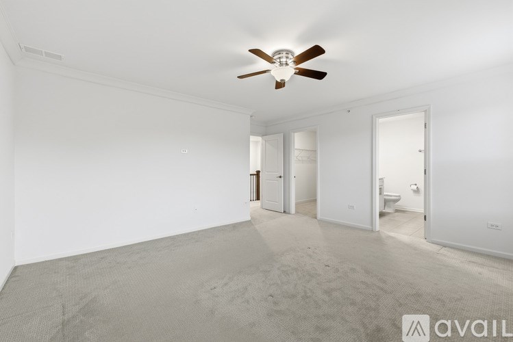 A spacious room with a ceiling fan and carpeted floor.