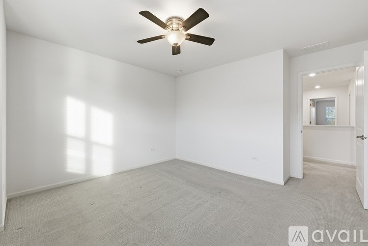 A room with a ceiling fan and carpeted floor.