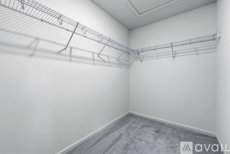 A room with a white wall and a grey carpet.