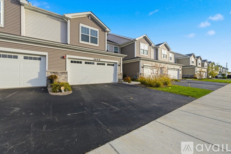 A row of houses with garages and driveways in front.