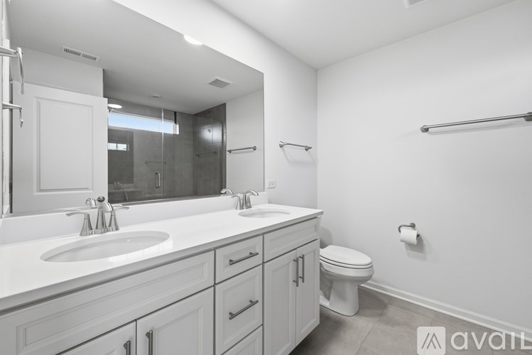 A bathroom with a toilet, sink, and mirror.