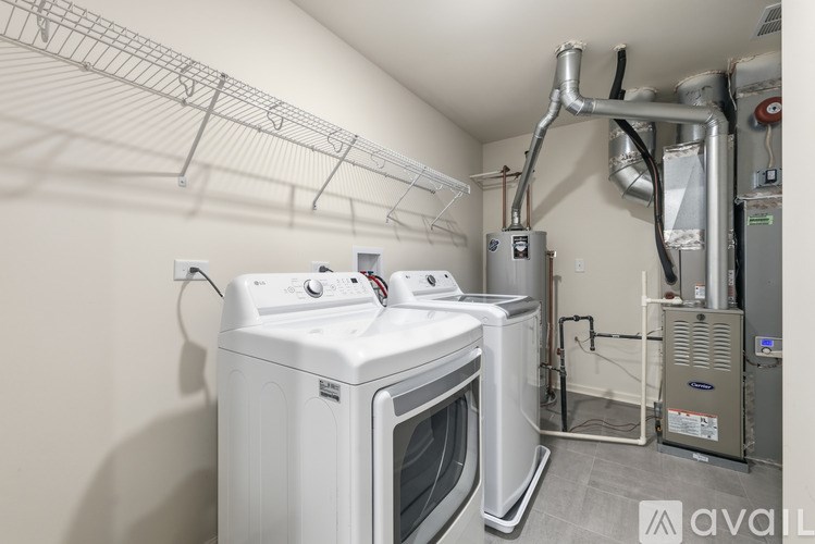 A white dryer and washer are installed in a laundry room.